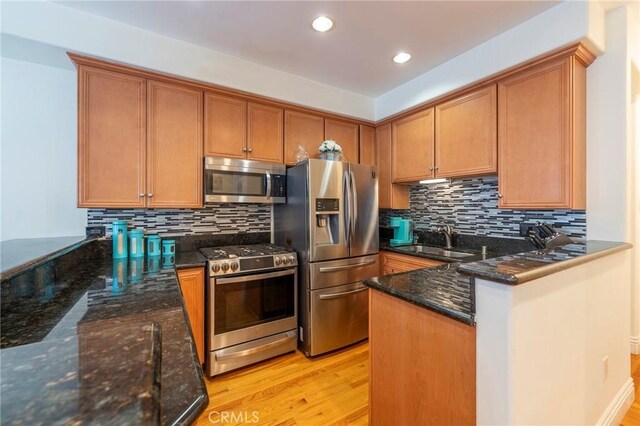 637 S Grand Ave Unit 4, San Pedro, CA 90731 - kitchen featuring stainless steel appliances, a peninsula, dark stone counters, light wood-type flooring, and recessed lighting