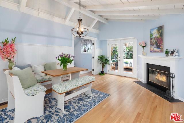 interior space with an inviting chandelier, lofted ceiling with beams, hardwood / wood-style floors, and french doors