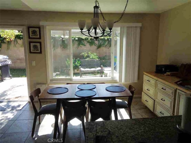 tiled dining space featuring plenty of natural light and a chandelier