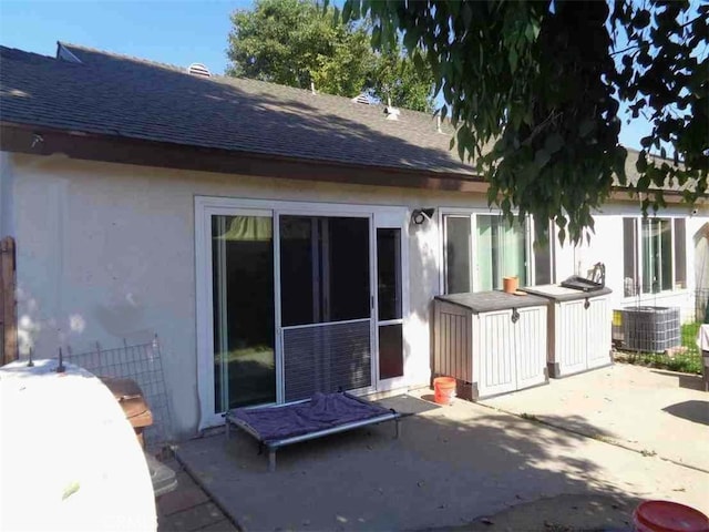 back of property with cooling unit and a patio