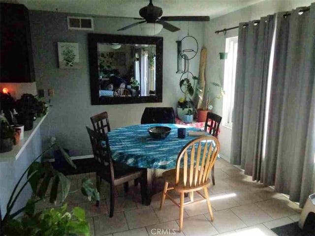 tiled dining area with ceiling fan