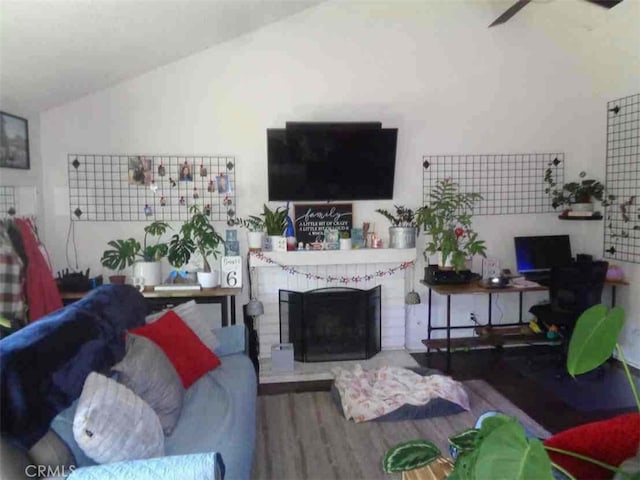 living room featuring a fireplace, ceiling fan, hardwood / wood-style floors, and lofted ceiling