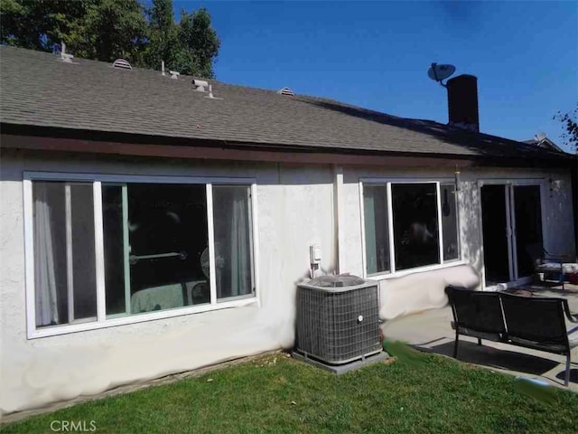 rear view of property featuring central AC unit and a patio