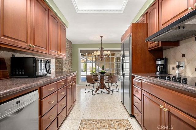 kitchen featuring exhaust hood, an inviting chandelier, black appliances, pendant lighting, and backsplash