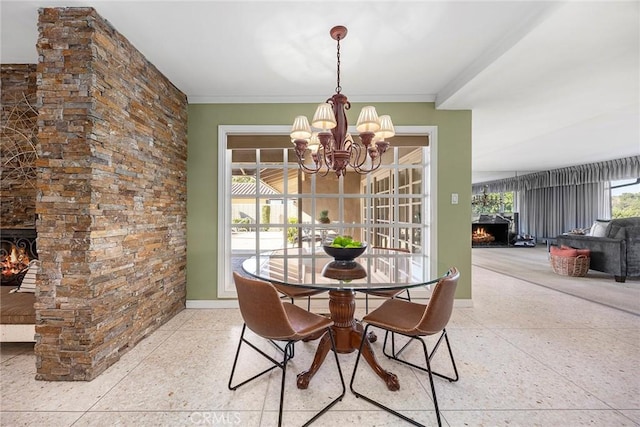 dining area with an inviting chandelier and a fireplace