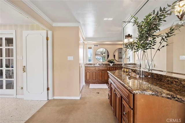 kitchen featuring light carpet, sink, crown molding, and dark stone countertops