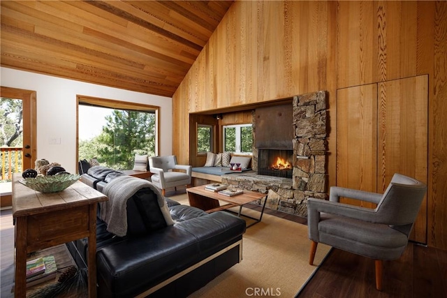 living room featuring wooden ceiling, high vaulted ceiling, wood walls, hardwood / wood-style floors, and a fireplace