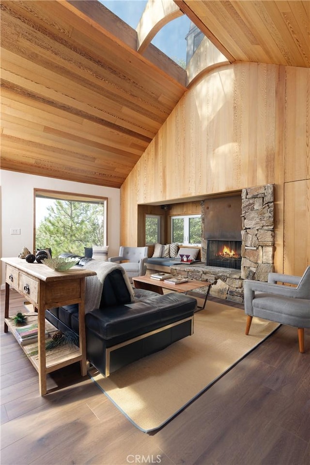 living room featuring a fireplace, hardwood / wood-style floors, wooden ceiling, and vaulted ceiling with skylight