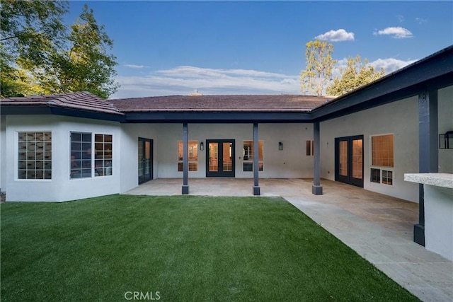 rear view of house featuring a yard, a patio area, and french doors