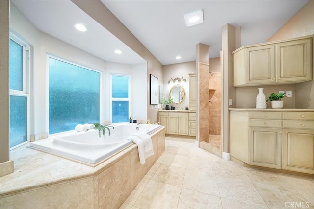 bathroom featuring plus walk in shower, vanity, and tile patterned floors