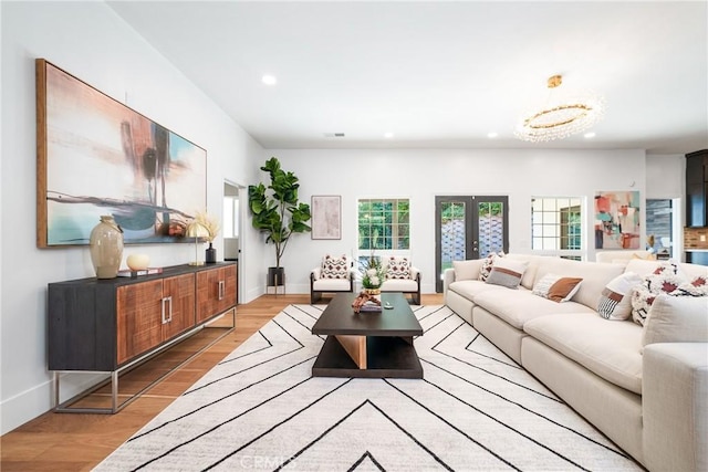 living room featuring plenty of natural light, a chandelier, and light wood-type flooring