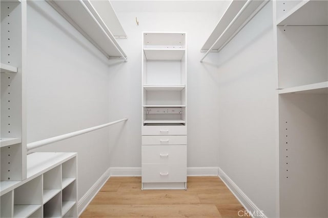 walk in closet with light hardwood / wood-style floors