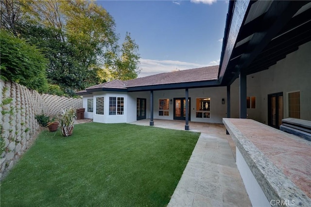 rear view of house with a lawn and a patio area