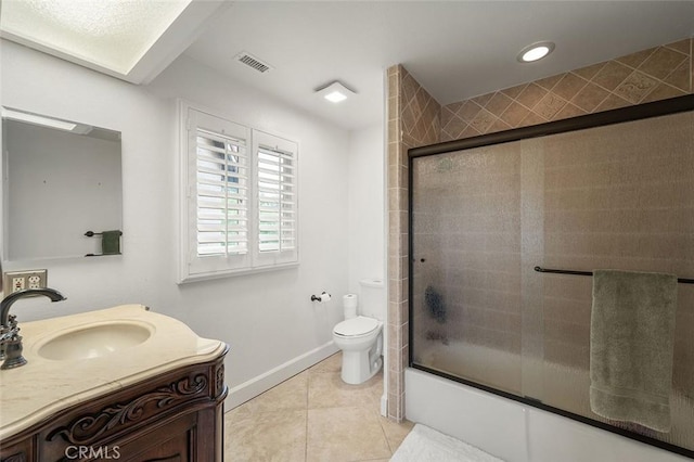 full bathroom featuring toilet, bath / shower combo with glass door, tile patterned floors, and vanity