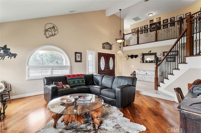 living room featuring high vaulted ceiling, hardwood / wood-style floors, and beam ceiling