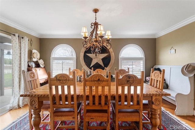 dining area with a healthy amount of sunlight, ornamental molding, and an inviting chandelier