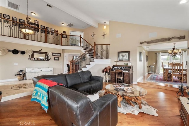 living room featuring hardwood / wood-style flooring, a notable chandelier, high vaulted ceiling, and beamed ceiling