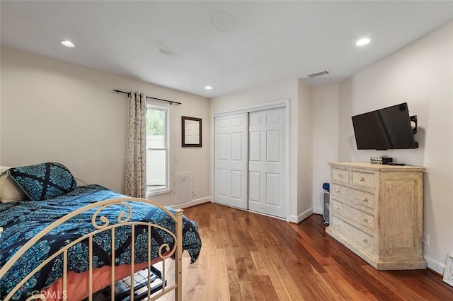 bedroom with dark wood-type flooring and a closet