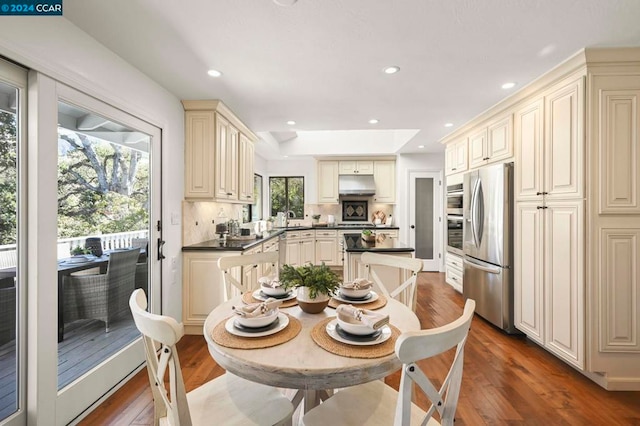 kitchen with dark hardwood / wood-style floors, sink, cream cabinetry, decorative backsplash, and appliances with stainless steel finishes