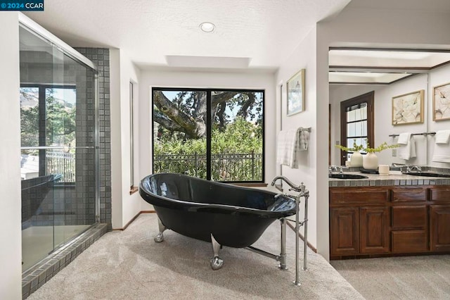 bathroom featuring a textured ceiling, independent shower and bath, and vanity