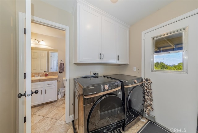 laundry room featuring cabinets, washing machine and clothes dryer, and sink