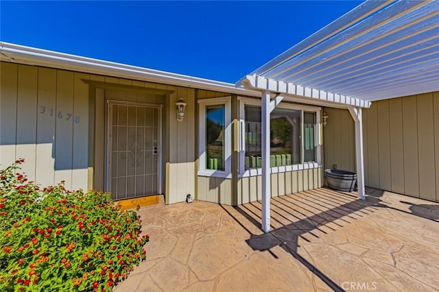 entrance to property featuring a pergola and a patio area