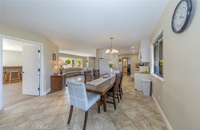 tiled dining space featuring an inviting chandelier