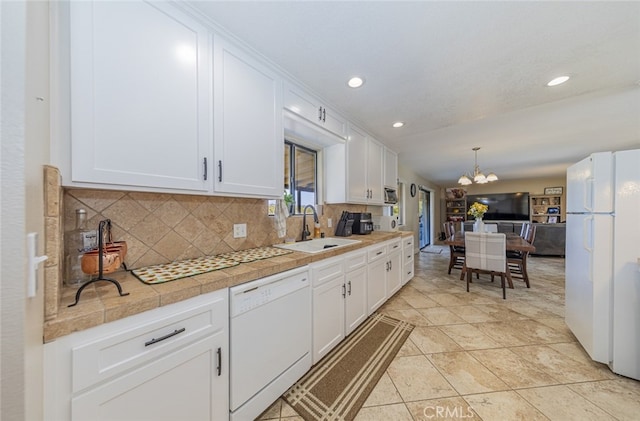 kitchen featuring decorative light fixtures, white cabinetry, sink, decorative backsplash, and white appliances