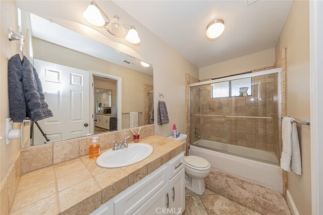 full bathroom with vanity, tile patterned floors, shower / bath combination with glass door, and toilet