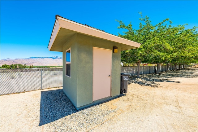 view of side of property featuring a mountain view and a storage shed