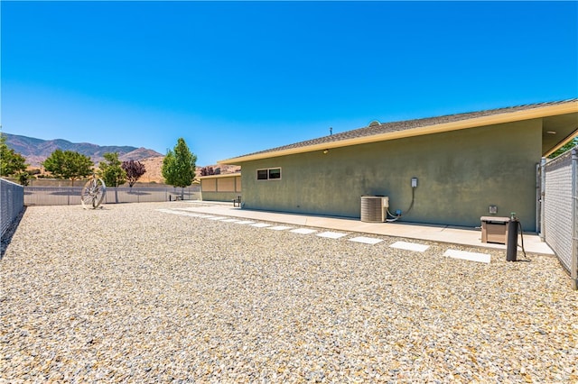 back of house featuring a mountain view, cooling unit, and a patio area