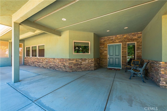 view of exterior entry featuring a patio area