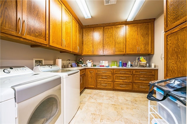 laundry area with washer and dryer, sink, and cabinets