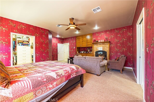 bedroom featuring a walk in closet, carpet flooring, and a closet