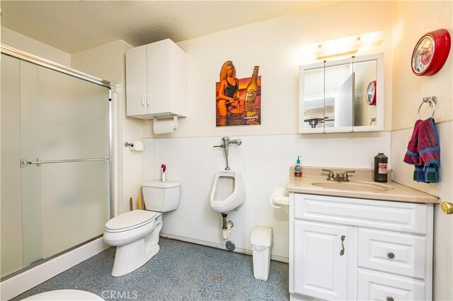 bathroom featuring vanity, a shower with shower door, and toilet