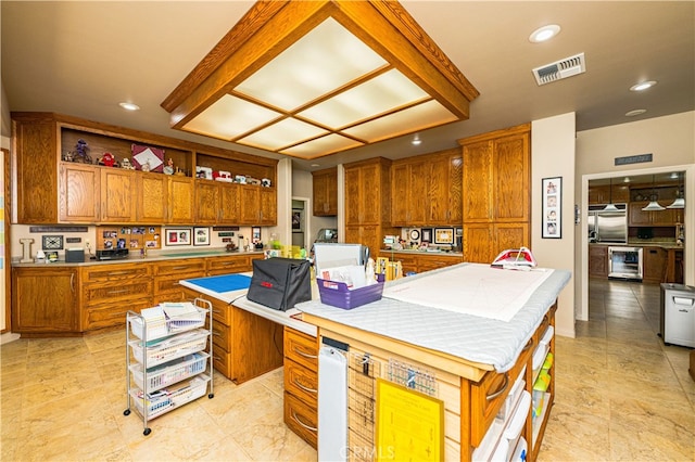 kitchen featuring a kitchen island with sink, built in desk, beverage cooler, and stainless steel built in fridge