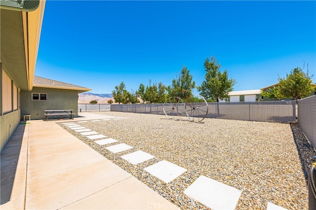 view of yard with a mountain view, a jacuzzi, and a patio area