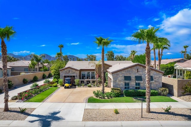 view of front of property featuring a front lawn, a mountain view, and a garage