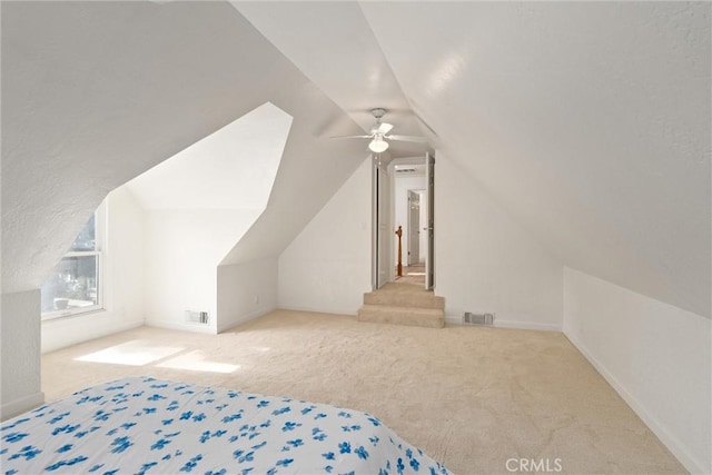 bedroom featuring vaulted ceiling, light carpet, and ceiling fan