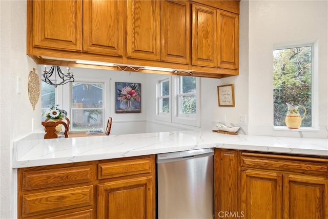 kitchen featuring light stone counters and dishwasher