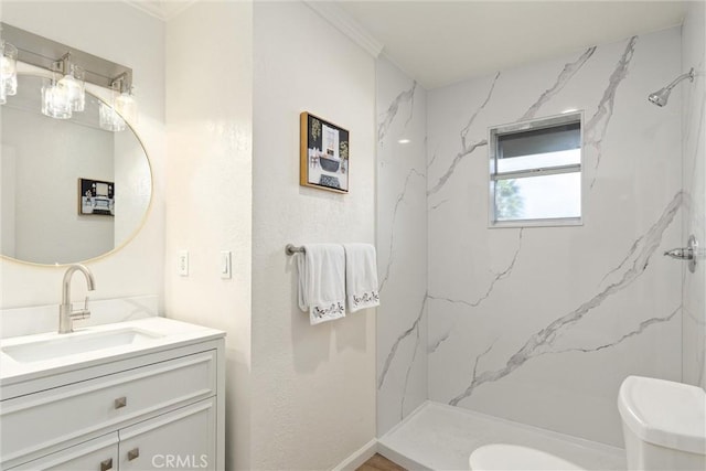 bathroom with vanity, a tile shower, and toilet