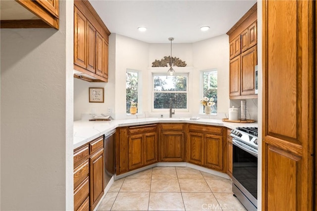 kitchen with light tile patterned flooring, stainless steel appliances, sink, and hanging light fixtures