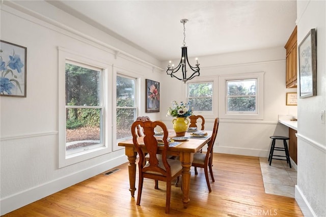 dining room with a chandelier and light wood-type flooring