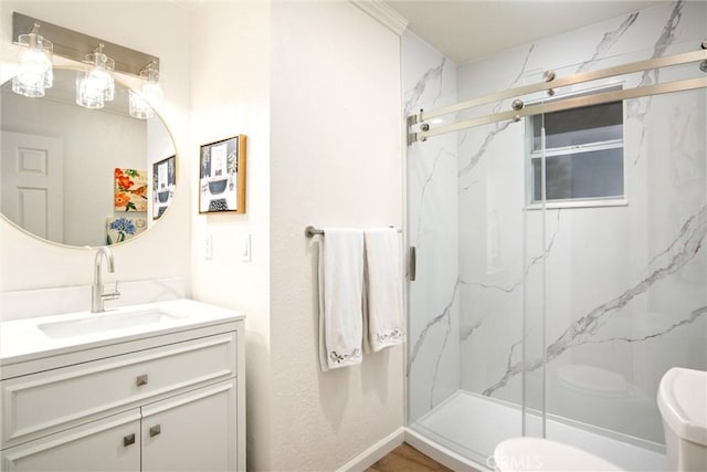 bathroom featuring vanity, a shower with shower door, and toilet