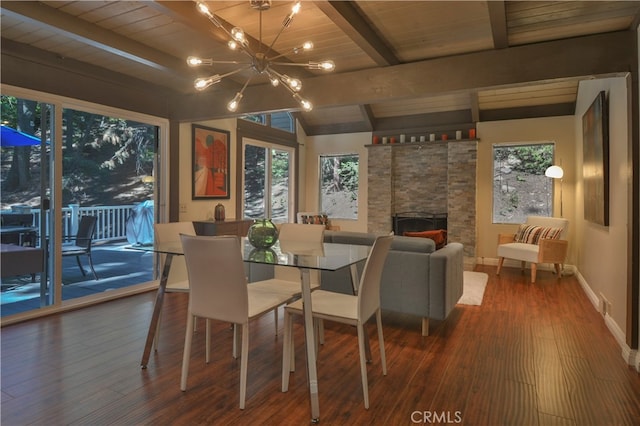 dining area with vaulted ceiling with beams, a stone fireplace, dark wood-type flooring, wooden ceiling, and an inviting chandelier