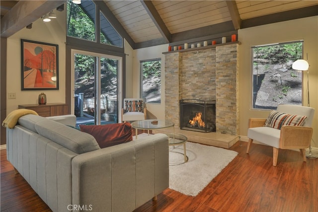 living room with a stone fireplace, beamed ceiling, dark wood-type flooring, and high vaulted ceiling