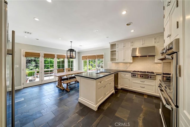 kitchen with kitchen peninsula, french doors, sink, pendant lighting, and white cabinetry