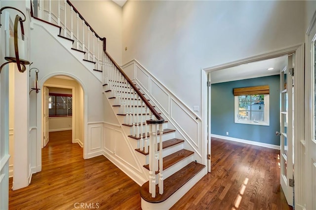 staircase featuring hardwood / wood-style floors and a high ceiling