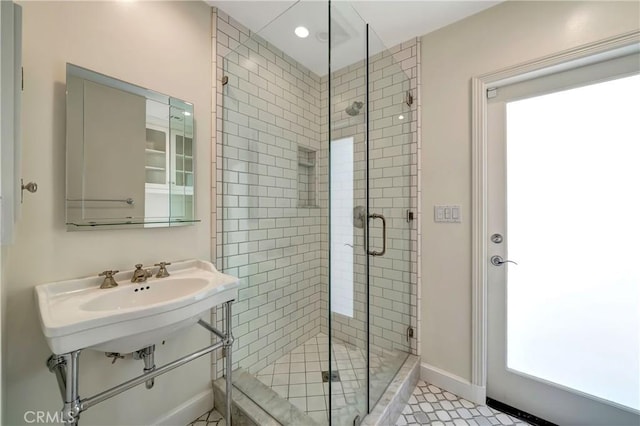 bathroom with tile patterned floors, a wealth of natural light, and a shower with shower door