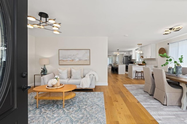 living room with an inviting chandelier and light hardwood / wood-style floors